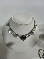 Necklace on display bust showing all charms and chain