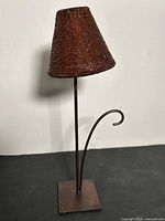 Full view of lamp showing beaded shade, metal post, curved arm, square base