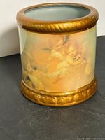 Side view showing cherub artwork and gold rim