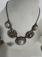 Front view of necklace on bust showing five floral stations