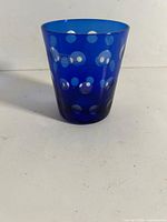Front view showing cobalt blue tumbler with cut white polka dots
