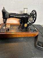 Full view of Singer Model 128 on wooden base with foot pedal