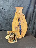 Full view of Earthworks vase and ceramic stove figurine on display