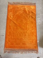 Full view of orange mihrab prayer mat showing design and size