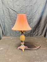 Full view of pineapple table lamp with shade and cord visible