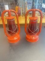 Pair of red Dietz Monarch hurricane lanterns front view