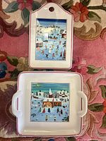 Overview of both porcelain serving pieces: rectangular board and square handled tray