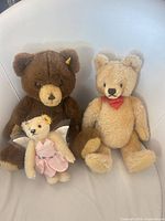 Group shot of three Steiff teddy bears on chair