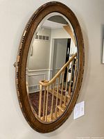 Full view of oval oak mirror on wall