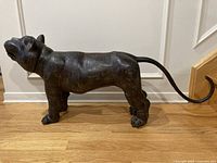 Side profile of full bronze feline figure