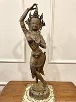 Full frontal view of the bronze Tara statue on table