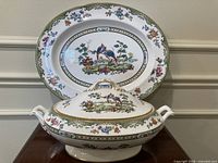 Tureen with lid in front of matching oval plate