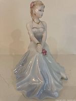 Front view seated lady figurine, dress details visible
