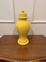 Front view of the yellow ceramic ginger jar on wooden surface