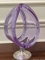 Front view of lilac glass sculpture on silver pedestal