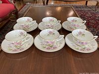 Six teacup and saucer sets arranged on table