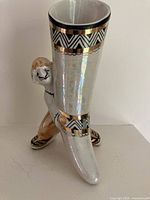 Front view of porcelain horn vase with supporting figure