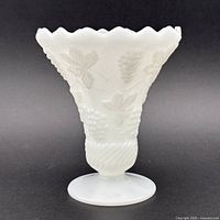 Full view of white milk glass vase showing ruffled rim and pedestal base