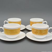 Set of four Arcoroc porcelain cups and saucers displayed together