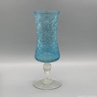 Full front view of blue crackle glass vase goblet on neutral background