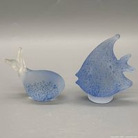 Front view of both blue and white blown glass fish figurines