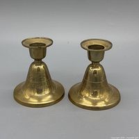 Front view of both brass candlesticks showing overall design and finish