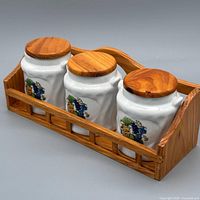 angled view showing three jars with lids seated in wooden rack