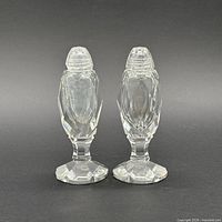 Front view of both faceted crystal shakers standing side by side