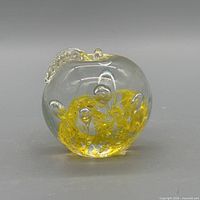Front view of clear and yellow floral glass paperweight