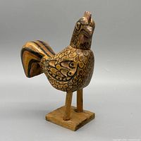 Front left view of carved wood rooster on base