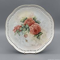 Front view showing floral artwork, pierced rim and signature