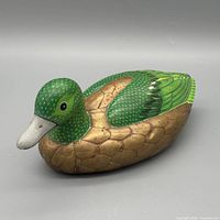 Left front view of carved wood duck showing head, body, color and texture