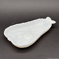 Side perspective of pear-shaped milk glass dish