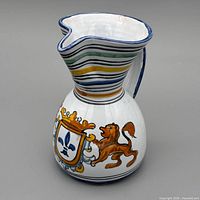 Three-quarter front view showing striped neck, crest decoration, spout shape