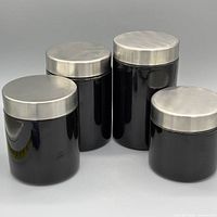 Full view of all four black ceramic canisters with stainless steel lids
