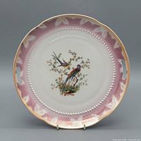front of porcelain plate showing bird motif, pink border, beaded rim, handles