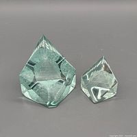 Both faceted teal-aqua glass paperweights front view