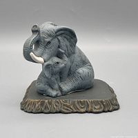 Front view of gray elephant mother and baby on brown base