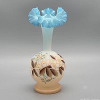 Front view showing blue ruffled rim and floral decoration
