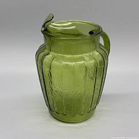 Front view of green ribbed glass pitcher showing ribs, crackle texture and ice lip