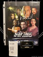 Front of autographed Star Trek cast photo in sleeve with Patrick Stewart silver signature, COA card displayed