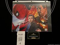 Front view of signed 8x10 photo in sleeve with signature visible and lot label