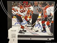 Full view of signed 8x10 photo showing both blue ink signatures and faceoff image