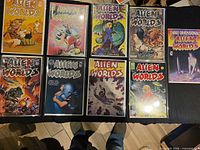 Nine bagged Alien Worlds comics arranged on table