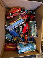 box containing assorted toy vehicles, some boxed