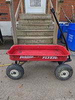 Side view of red Radio Flyer wagon showing wheels, handle and logo