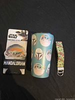 Group shot of tumbler, packaged can cooler, key strap