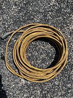 Coiled yellow heavy-duty 3-prong extension cord, approximately 50 ft