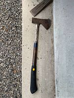Full view of axe and partial splitting wedge on floor