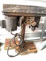 Full view of bench drill press showing base, column, table, motor, and cord